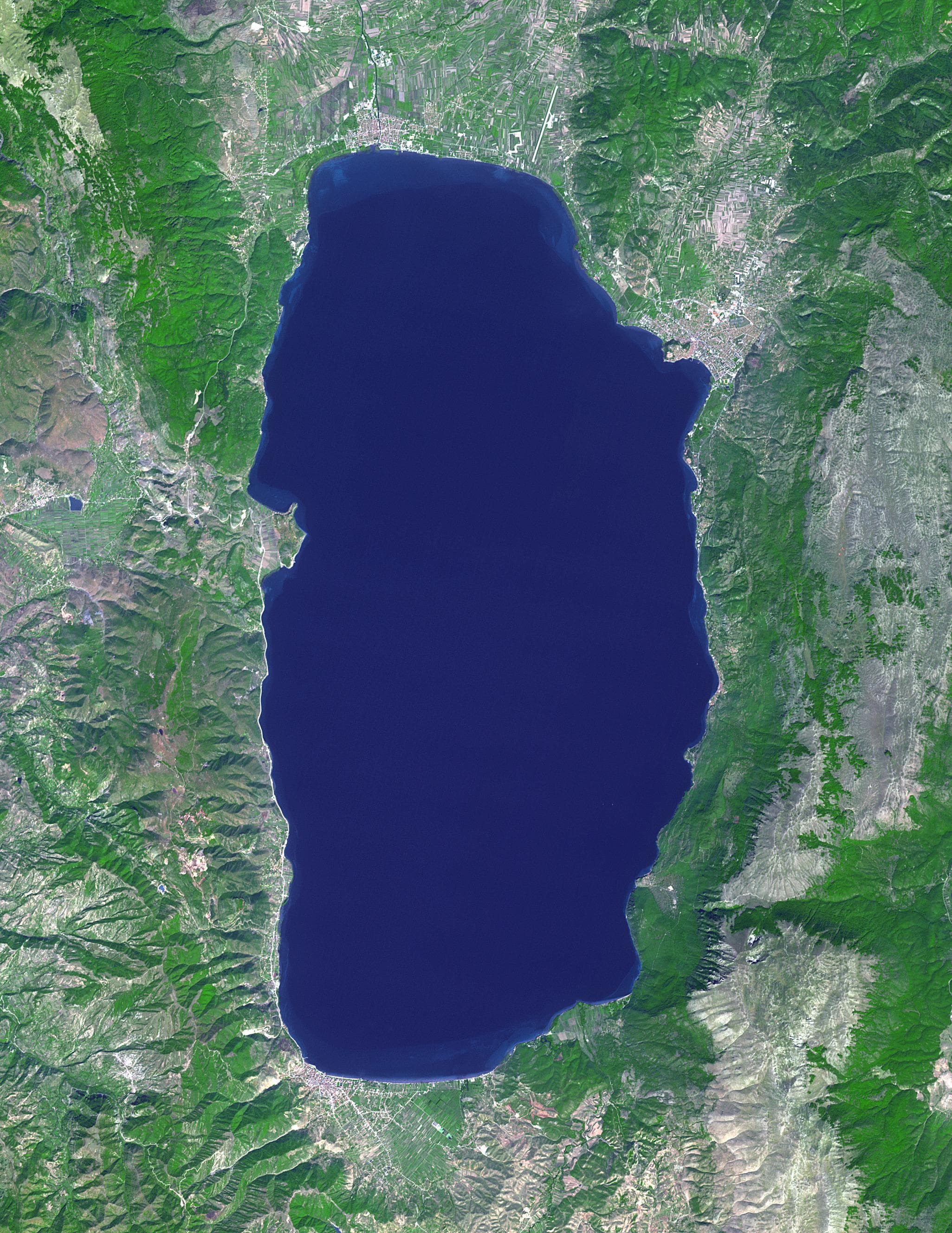 The blue water of Lake Ohrid with a small town and mountains on the far shore