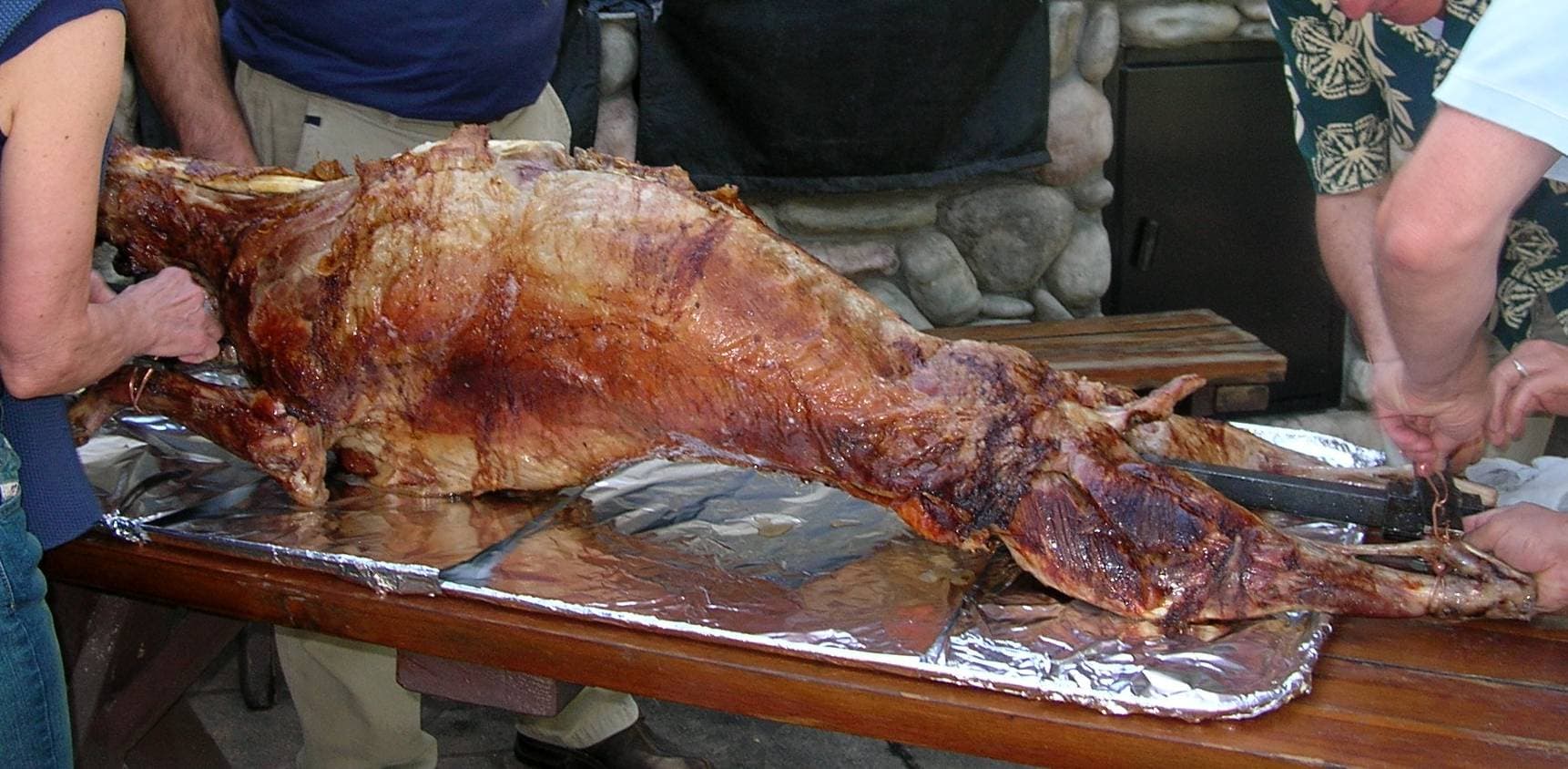 A whole lamb being slowly roasted over hot coals at an Algerian celebration