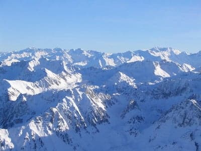 Snowy Pyrenees mountain peaks above a green Andorran valley