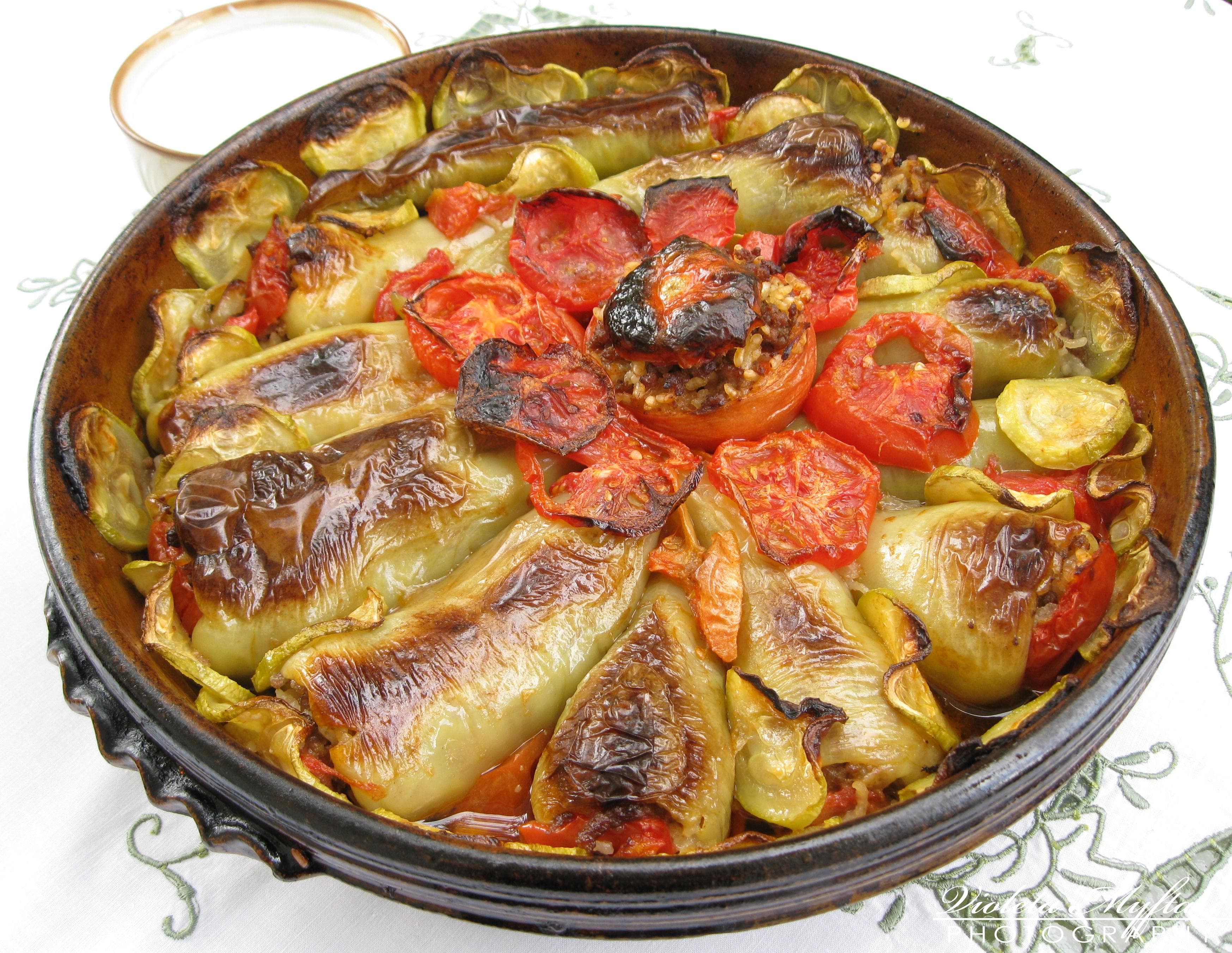 A plate of small green vine-leaf dolmas arranged in neat rows