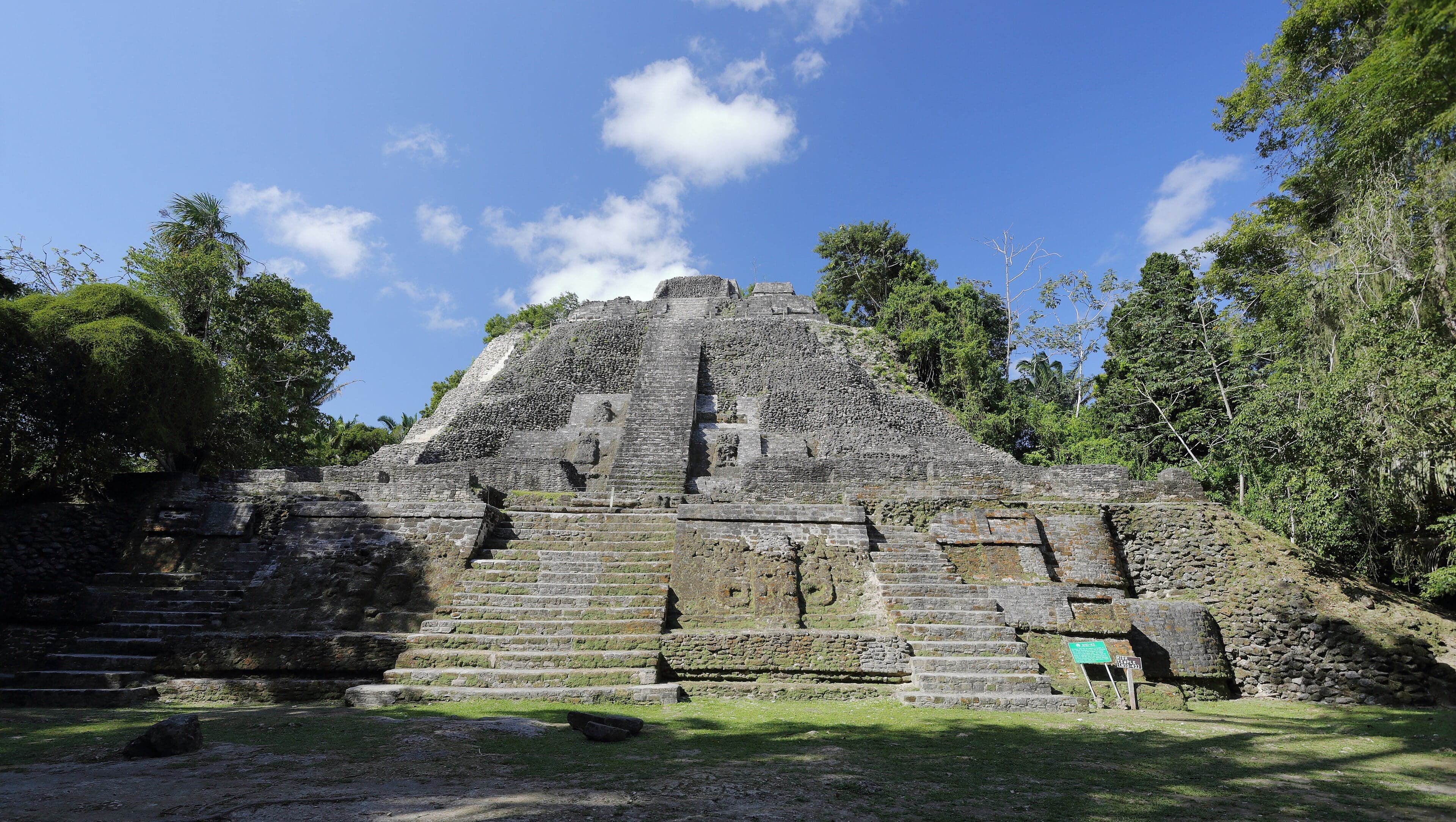 A tall Maya temple rising from green jungle beside the New River Lagoon