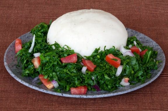 A bowl of thick smooth bogobe porridge served in a traditional clay bowl