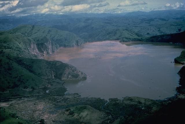 The deep blue-green waters of Lake Nyos in its volcanic crater