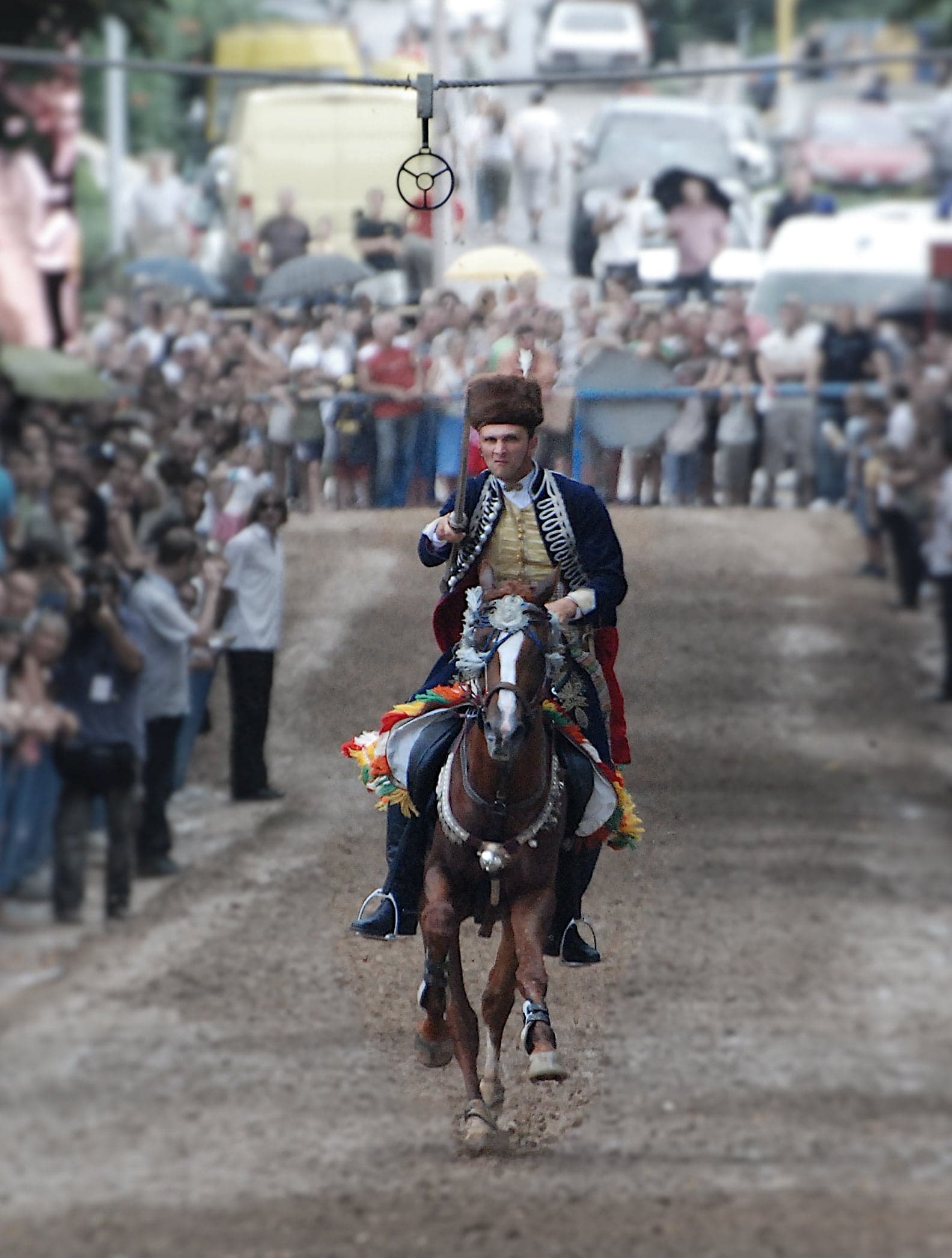 A rider in traditional armour on horseback at full gallop during the Sinjska Alka tournament