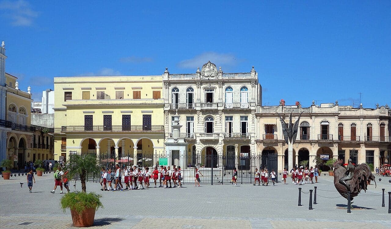 Colourful colonial buildings lining a wide plaza in Havana Old Town