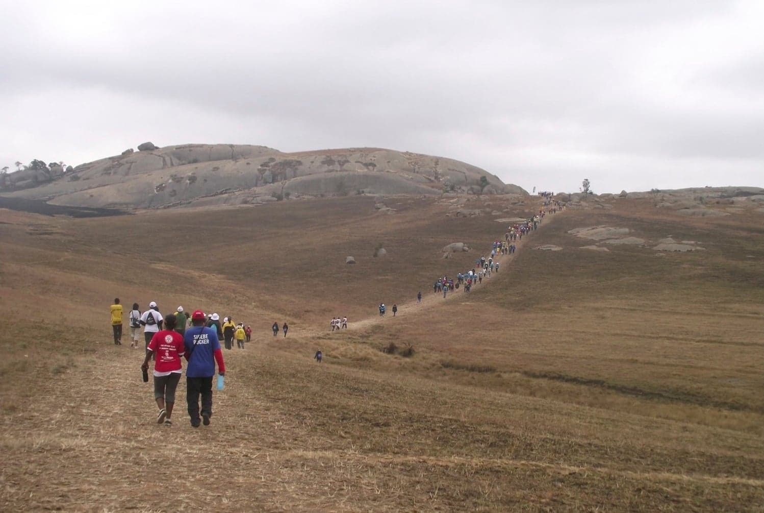 The vast smooth granite dome of Sibebe Rock rising above green hills