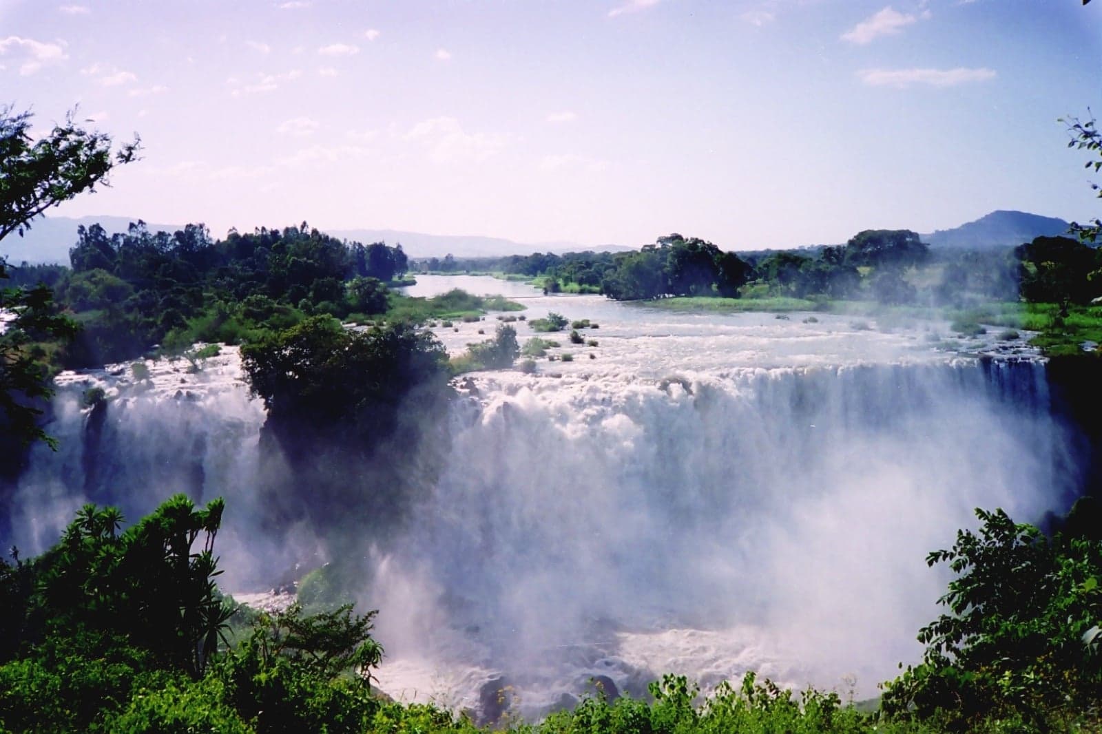 The wide curtain of the Blue Nile Falls, with mist rising from the gorge
