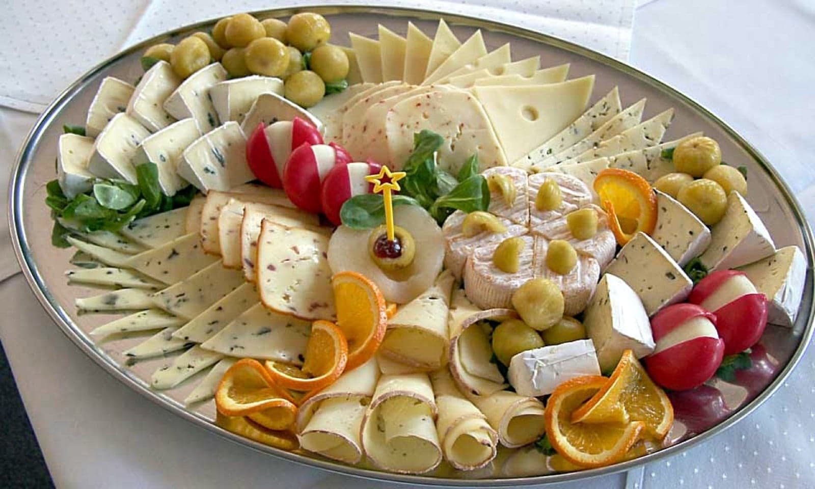 A large platter of many different French cheeses