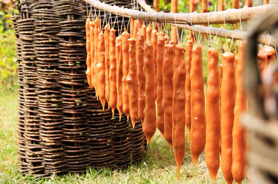 Colourful strings of churchkhela hanging in a Georgian market, looking like long candles