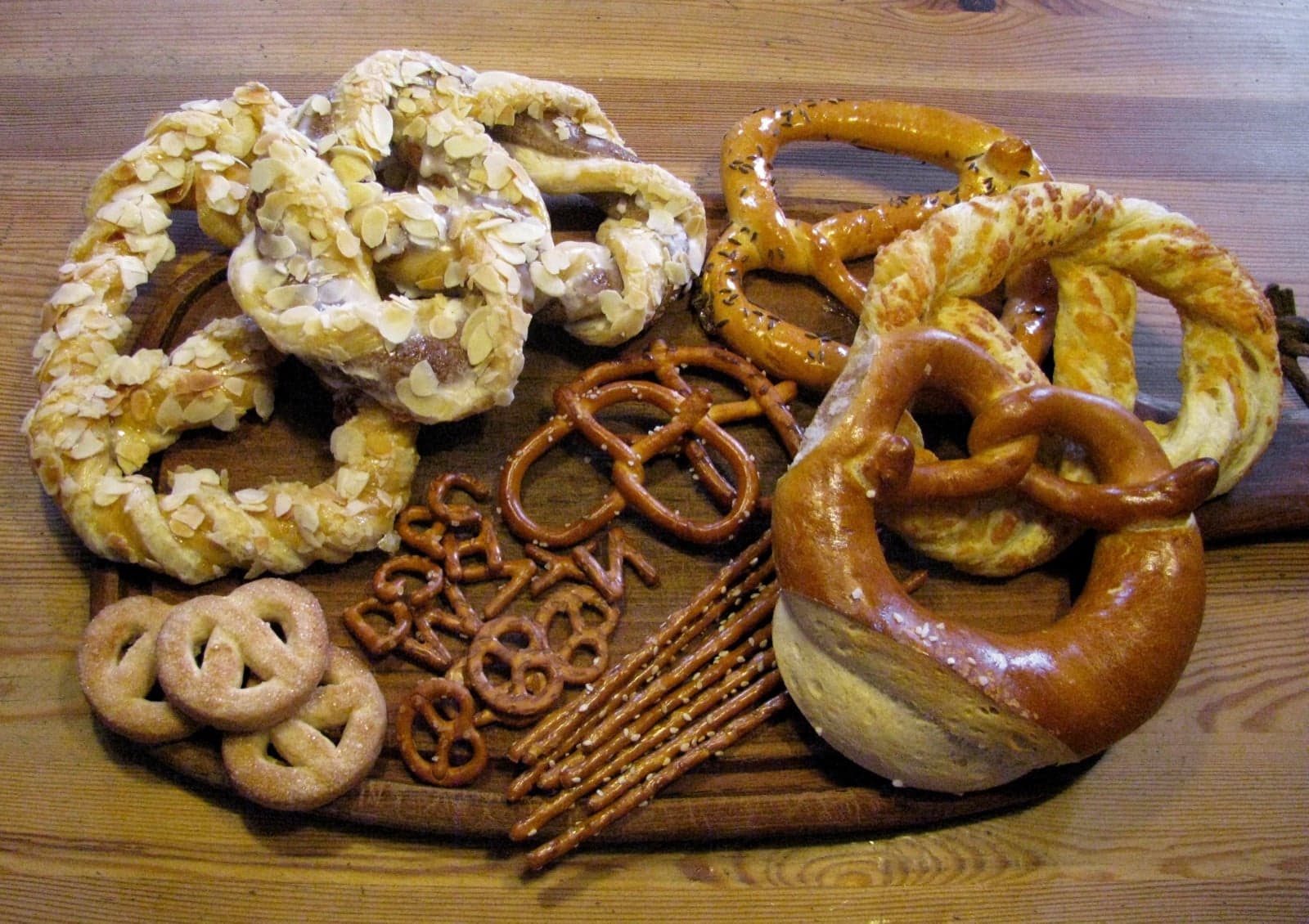 A wooden board with several different kinds of German pretzels