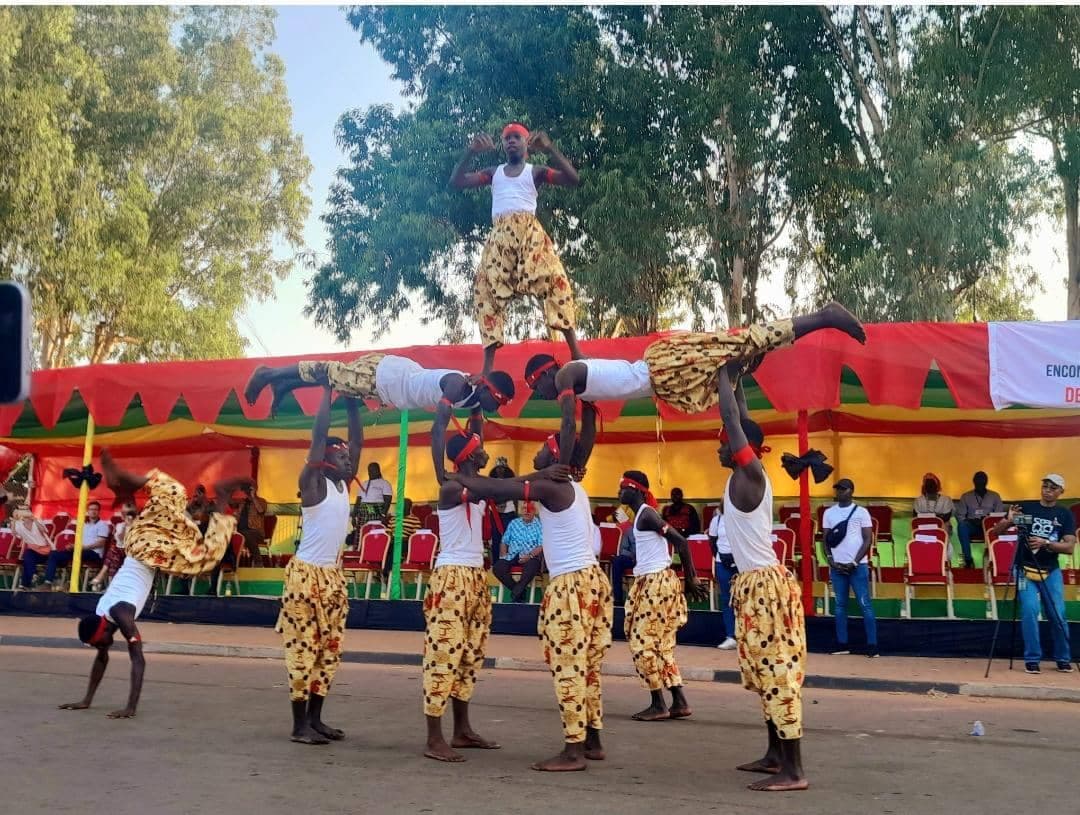 Dancers in bright feathered costumes parading through the streets of Bissau during Carnival