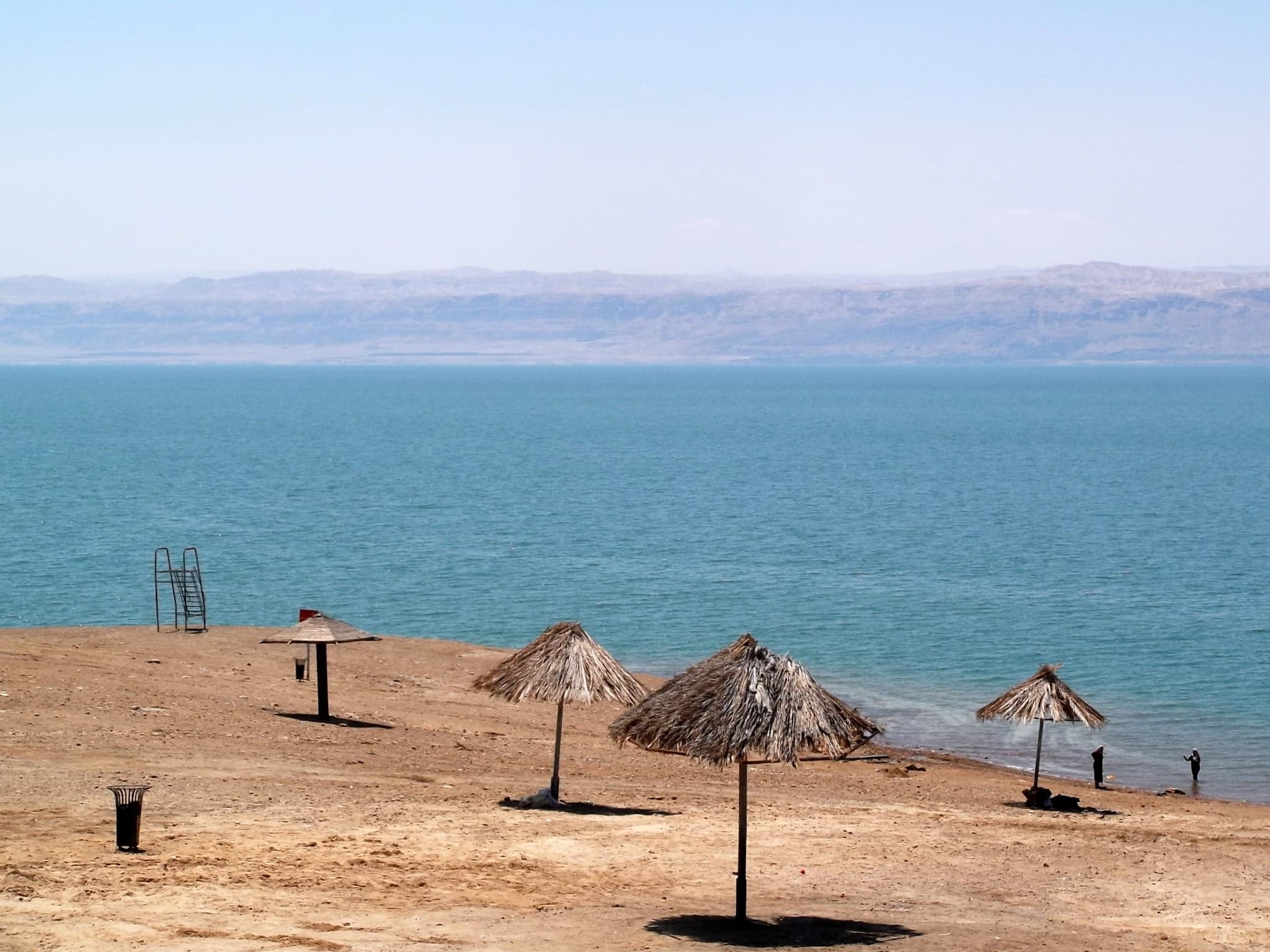 A person floating effortlessly on the brilliant blue surface of the Dead Sea