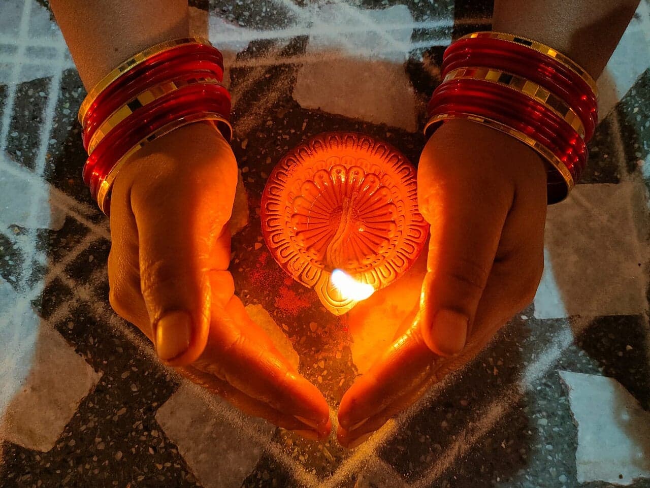 Rows of small clay oil lamps glowing at night during Diwali celebrations in Mauritius