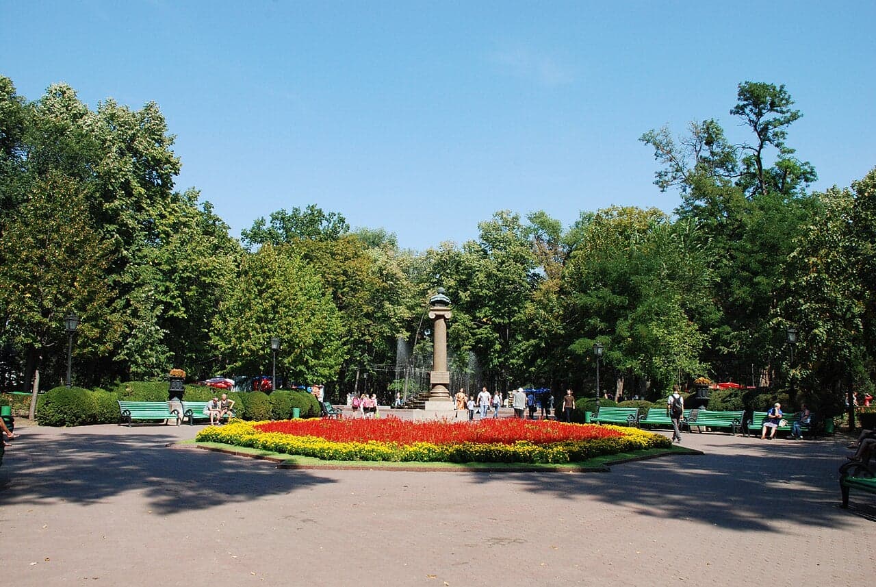 A wide tree-lined boulevard in central Chișinău with flower beds and benches
