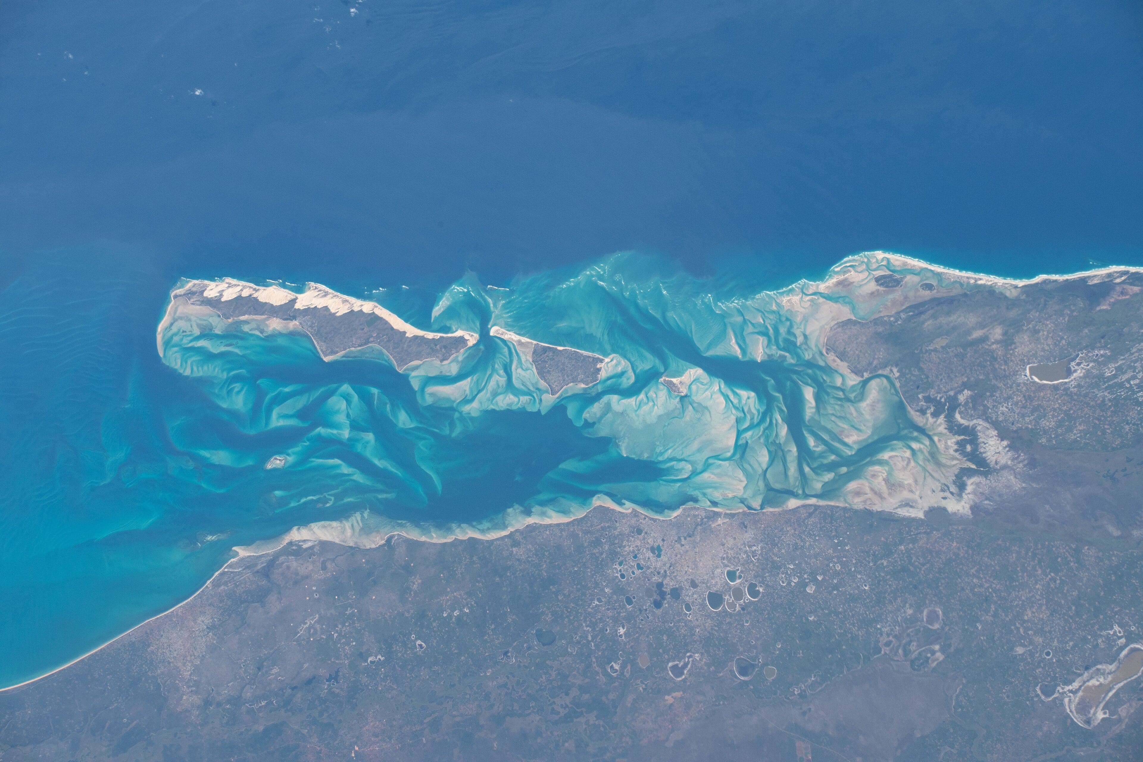 Crystal-clear turquoise water surrounding a white sand island in the Bazaruto Archipelago