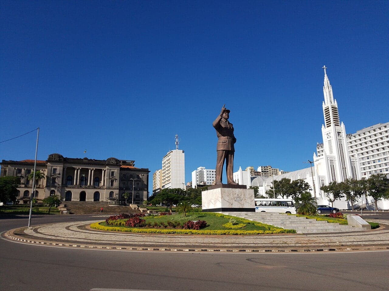 Crowds celebrating Mozambique Independence Day with flags and colourful costumes in a city square
