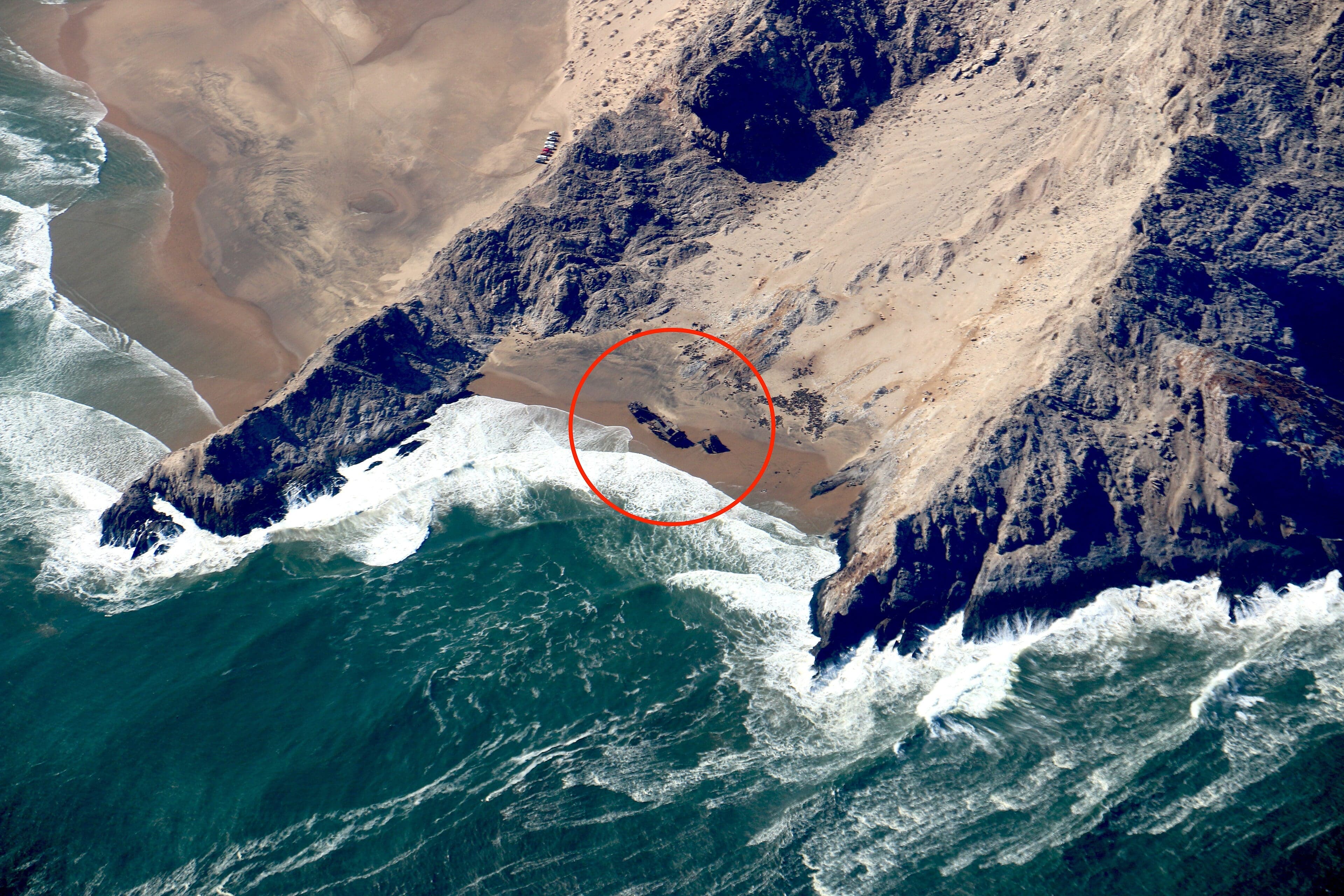 Waves crash on a deserted beach where sand dunes meet the Atlantic Ocean