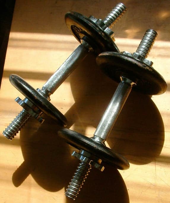 A weightlifter lifting a heavy barbell overhead at a competition