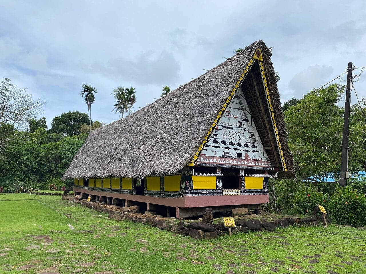 A traditional Palauan bai meeting house with a high gabled roof decorated with colourful painted panels