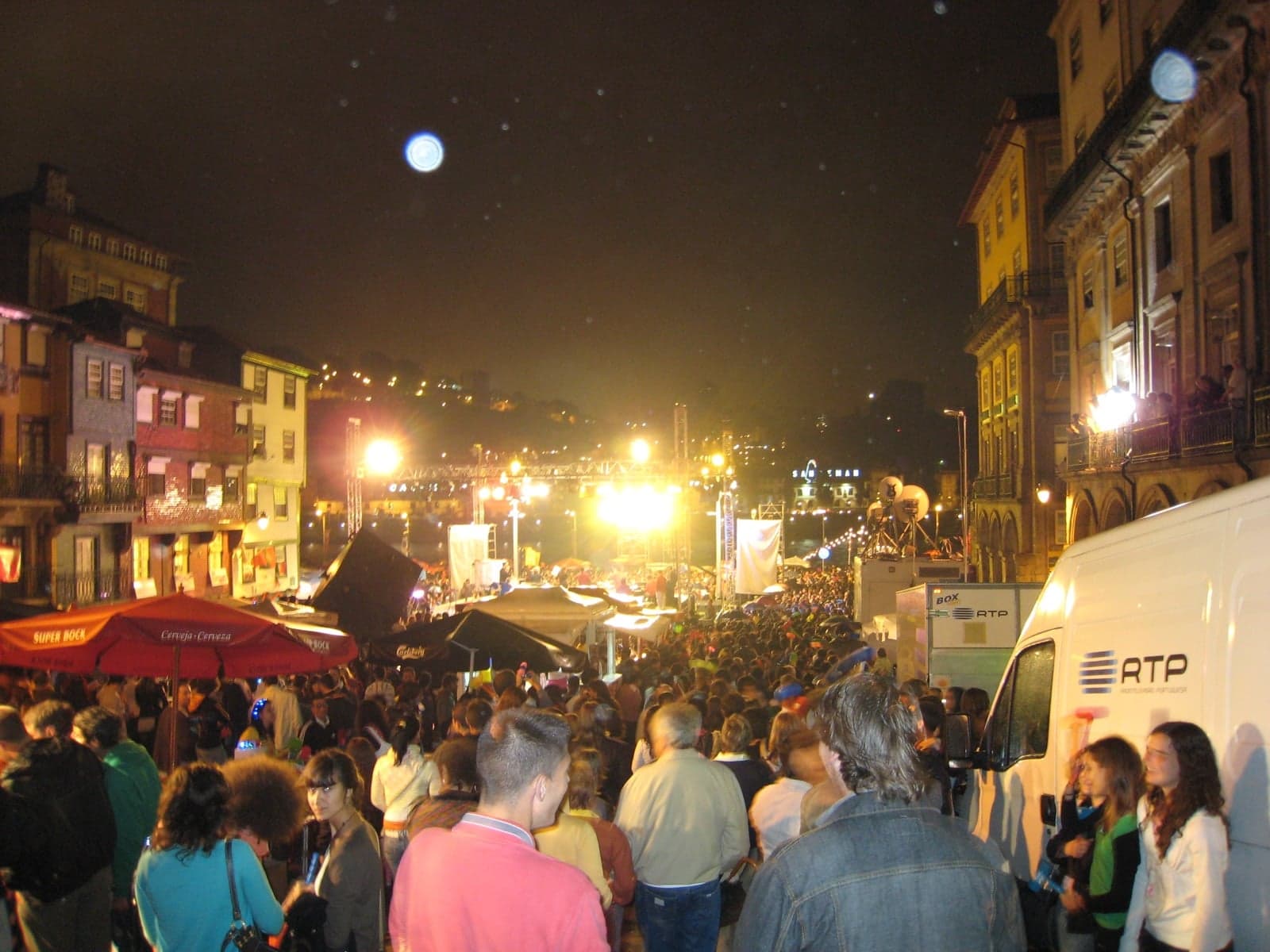 People celebrating Festa de São João in Porto with paper lanterns and lights