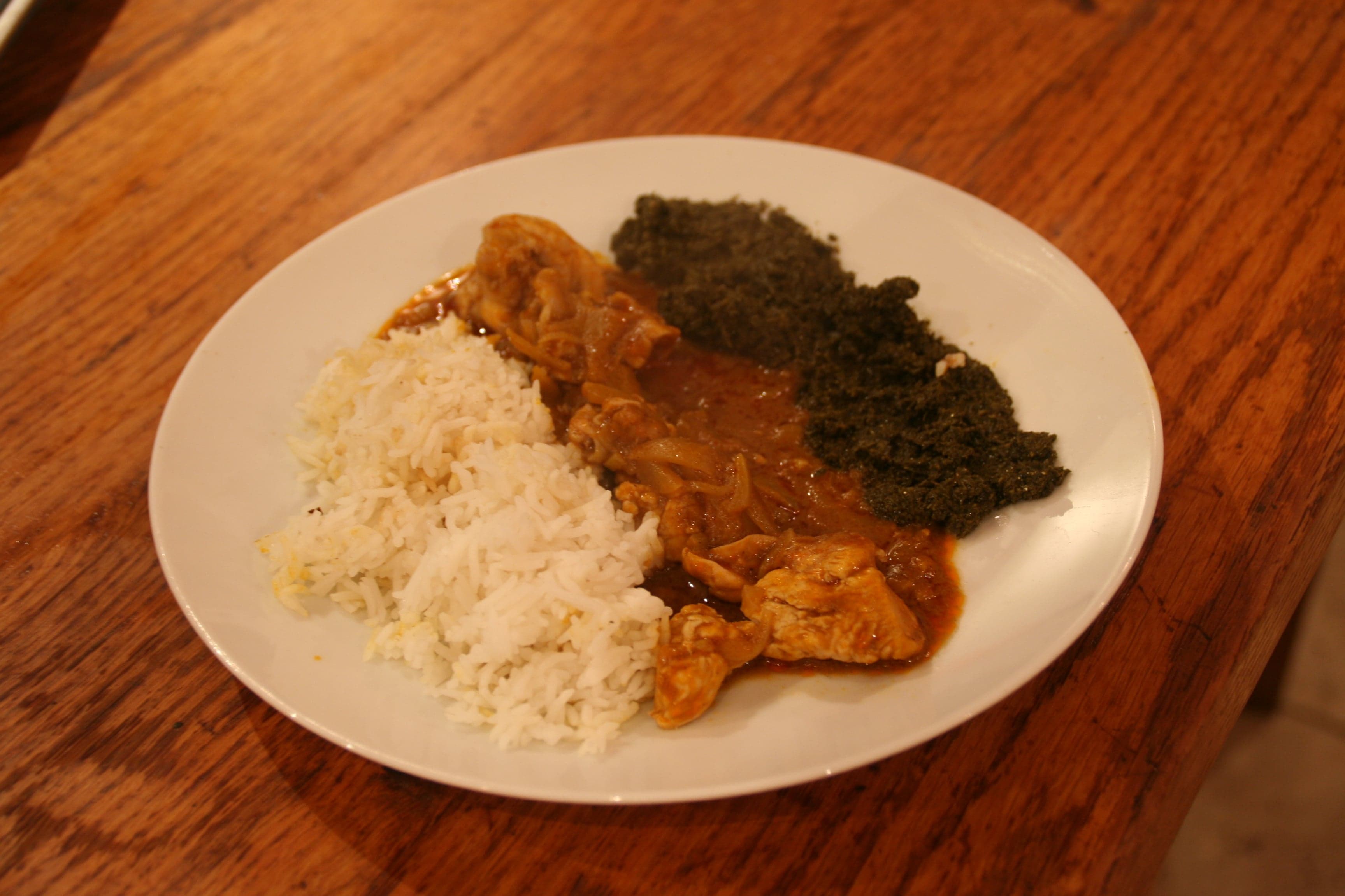 A pot of poulet à la moambé - chicken cooked in rich red palm-nut sauce