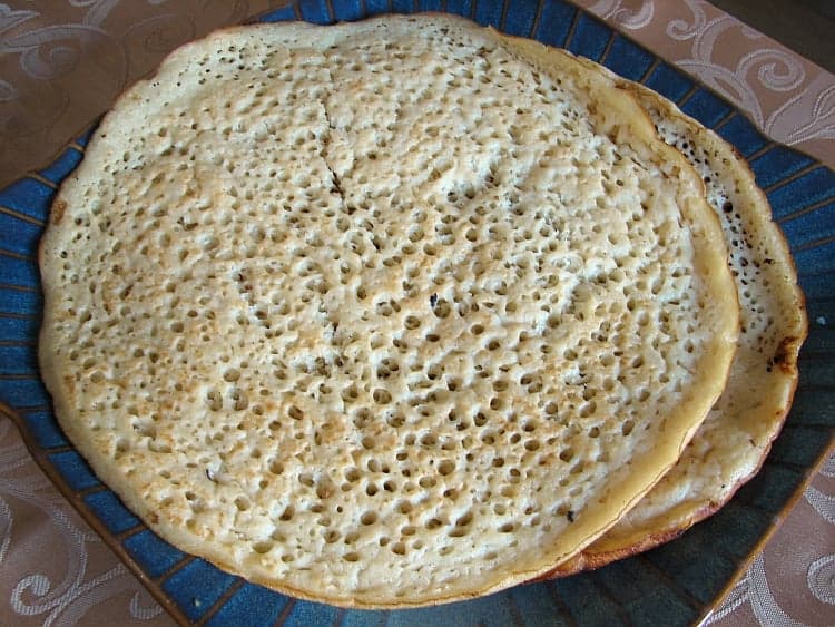 A stack of spongy canjeero flatbreads showing their characteristic bubble-covered surface