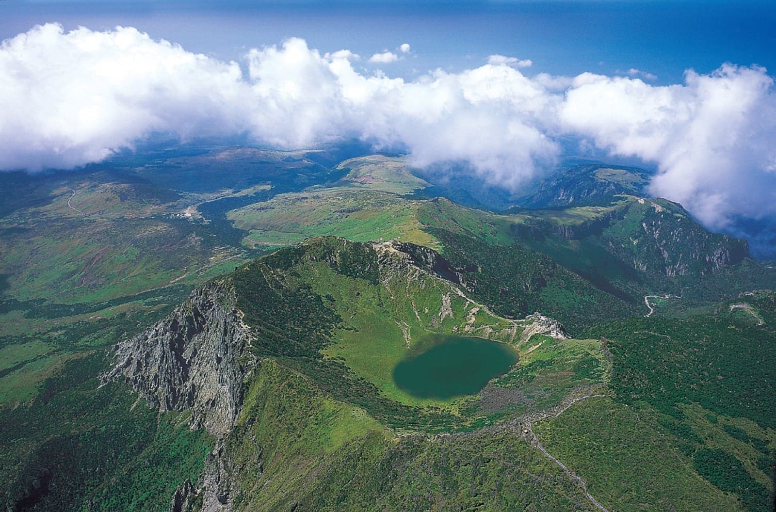 Aerial view of a green crater lake at the top of Hallasan volcano on Jeju Island
