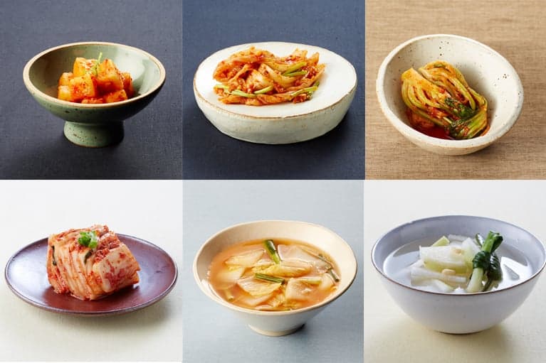 Six small bowls of different colourful kinds of kimchi