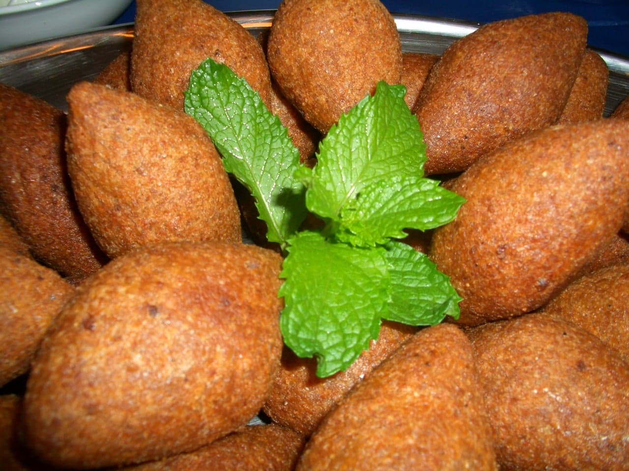 Golden oval-shaped kibbeh pieces on a serving plate