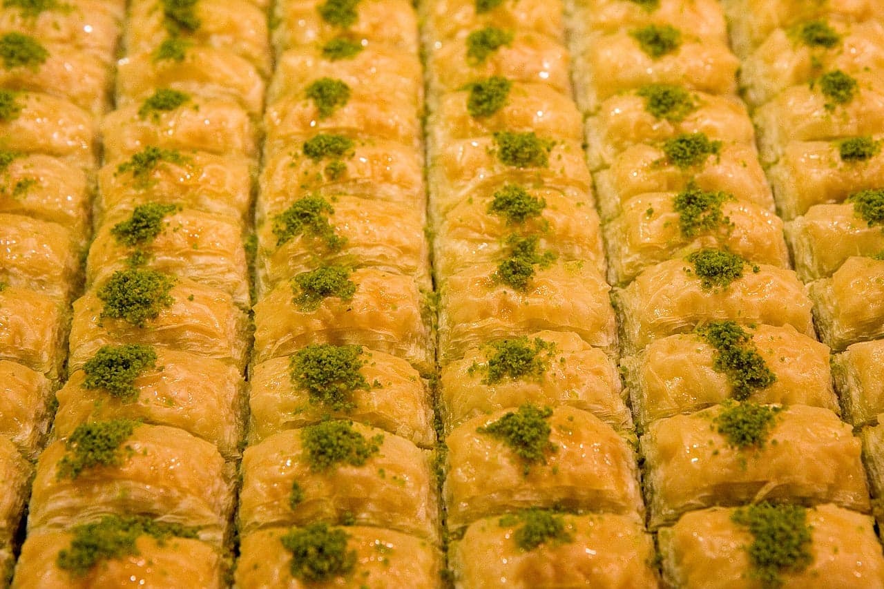 Pieces of golden baklava layered with chopped pistachios and honey syrup