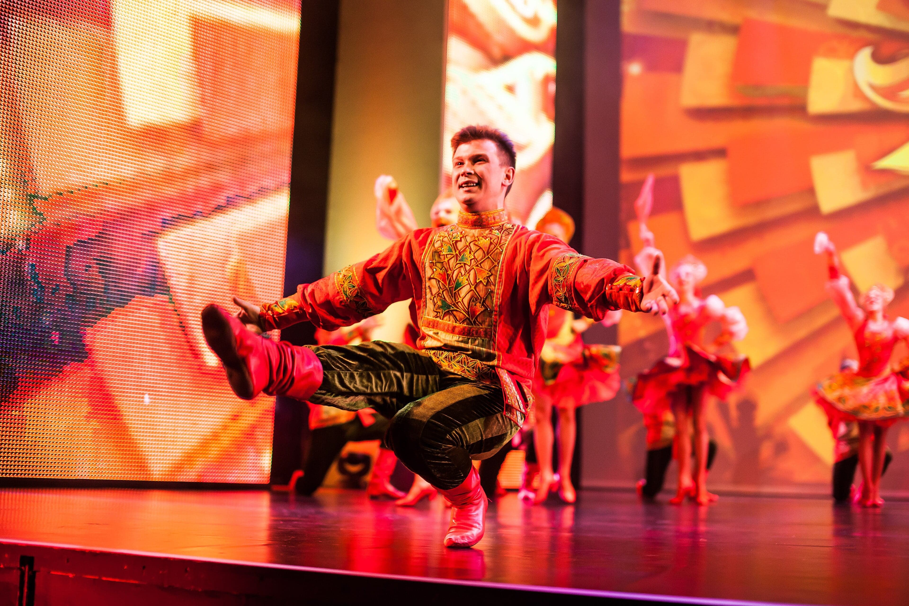 Dancers in bright red boots and embroidered costumes performing hopak