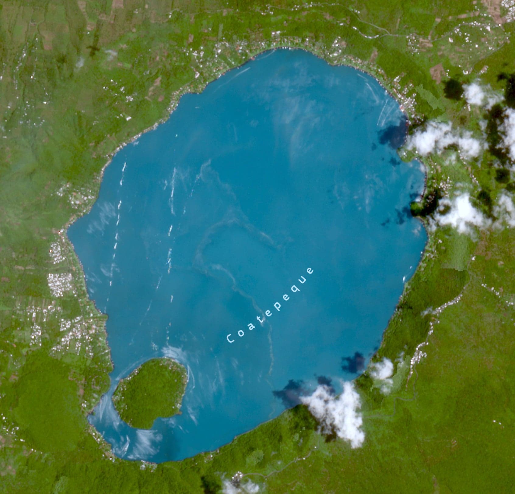 The vivid blue water of Lake Coatepeque surrounded by green hills