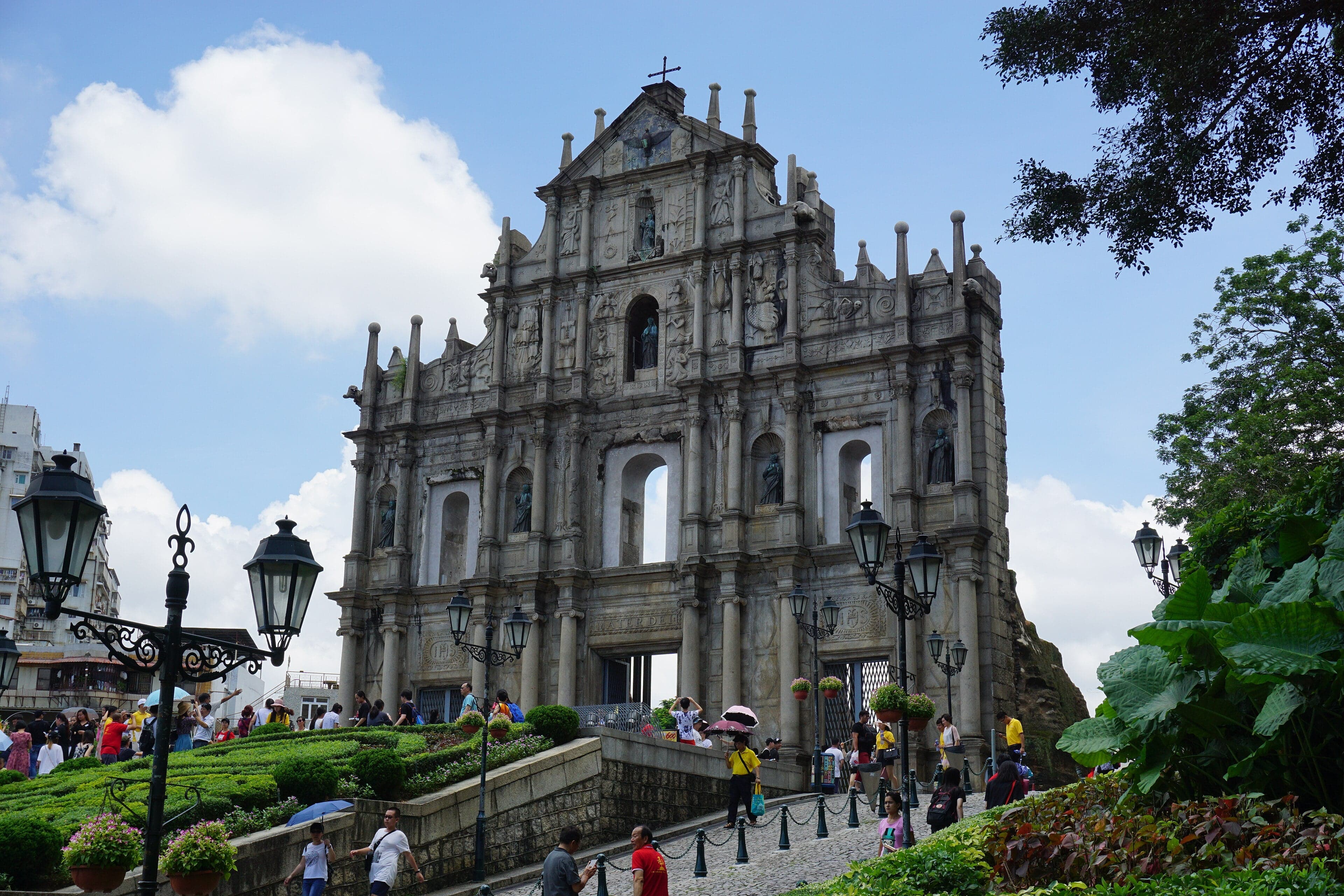 The ornate stone facade of the Ruins of St Paul's standing alone against a blue sky in Macau
