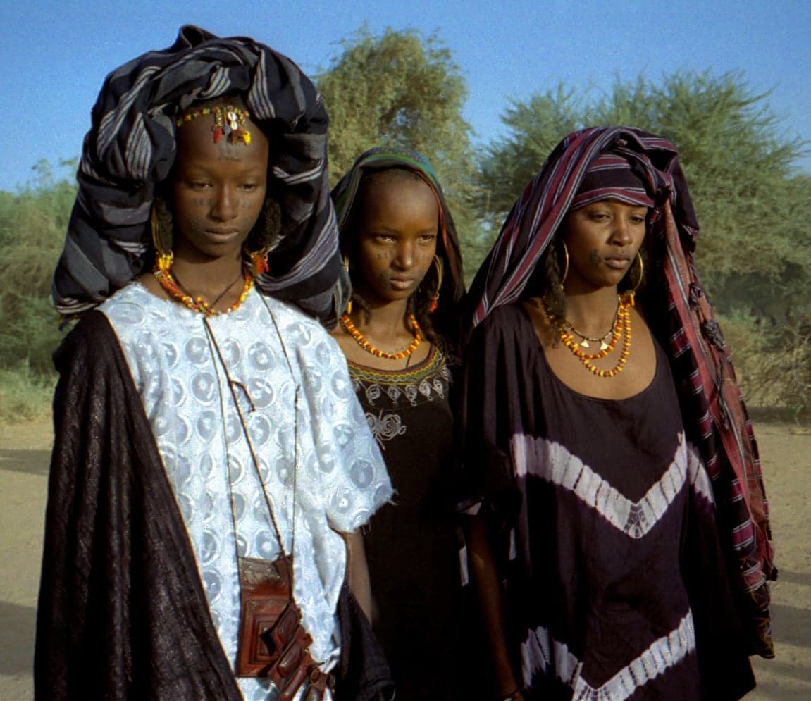Wodaabe men in colourful costumes and elaborate face paint dancing at Gerewol